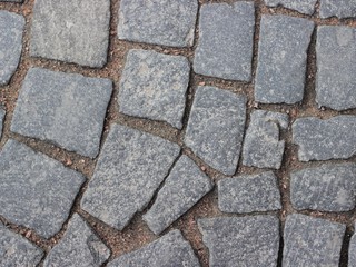 Pavement paved stones. Abstract background of old cobblestone pavement close-up.