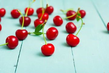 Obraz na płótnie Canvas sour cherry fruits on old blue wooden table background
