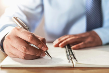 businessman writing on note book in office