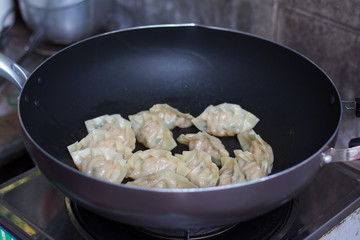 fried dumplings Gyoza with pork stuff during cooking on a pan