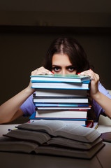 Young female student preparing for exams late at home 