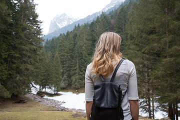 Caucasian girl walking in a mountain trail during her adventurous solo travel in the wild italian alps