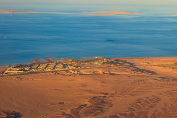 Aerial view on Red sea, Arabian desert and touristic resort near Hurghada, Egypt. View from airplane