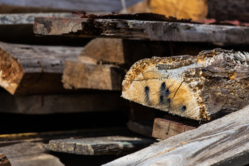 A stack of old wooden planks that lie on the ground