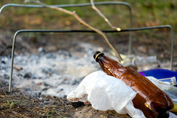 A pile of garbage in the forest park near the campfire site. environmental pollution