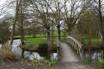 Fototapeta na wymiar Jolie passerelle pour franchir le ruisseau qui coule dans ce parc à Availles sur Seiche dans le département de l'Ile et Vilaine en Bretagne