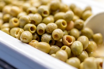 Close up of fresh and organic pitted olives on a luxury Greek buffet with a serving spoon