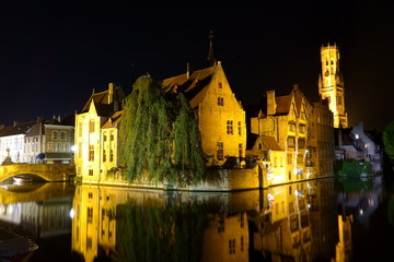 Fototapeta na wymiar Night View of the Rozenhoedkaai (canal) in Bruges (Belgium) under backlight with the Belfry in the background