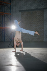 An athletic man on capoeira training. Staning in the pose. Standing on hands