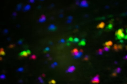 Blurred city night light reflection. Glowing multicolor spots. Bokeh lens flare effect.