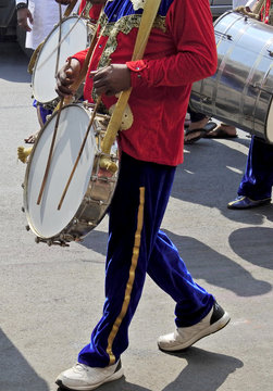 Indian Hindu man, a drummer playing the drums, during religious procession