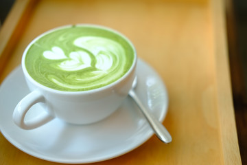 hot matcha green tea latte on wood table.