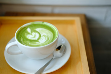 hot matcha green tea latte on wood table.