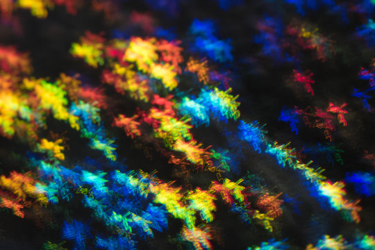 Blurred neon lights in motion. Thin curved multicolor lines on dark background. Lens flare effect.