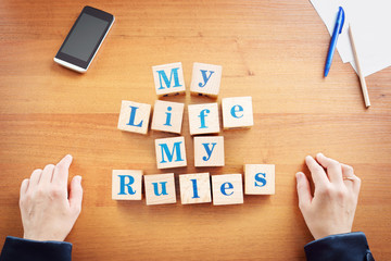 My life My rules. Business woman made text from wooden cubes on a desk