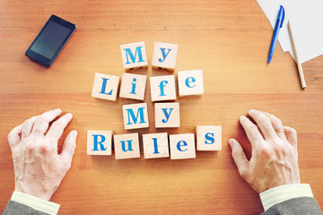 My life My rules. Businessman made text from wooden cubes on a desk