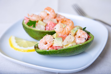 Salad with shrimps, avocado, pineapple and grapefruit in half avocado. Selective focus, close-up.