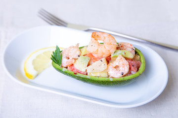 Salad with shrimps, avocado, pineapple and grapefruit in half avocado. Selective focus, close-up.