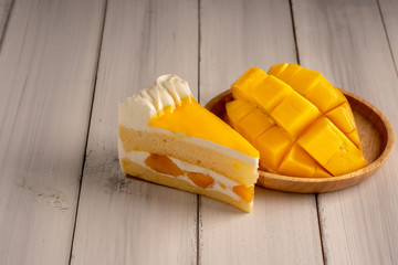Mango cake, mango fruit cut into pieces in wooden dish on white wooden.