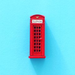 London traditional red phone booth over blue background.