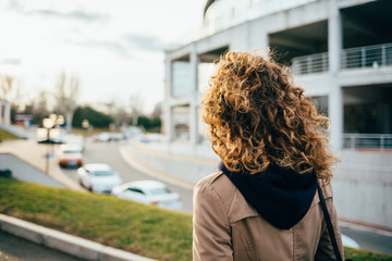 Rear view young woman wearing beige coat
