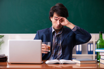 Male teacher drinking in the classroom 