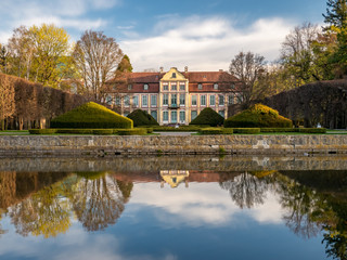 Fototapeta na wymiar Abbots Palace in the rococo style and located in Oliwa Park. Early spring scenery. Gdansk, Poland. 