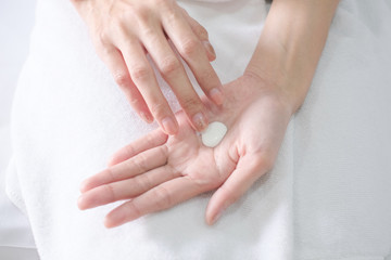 Asia woman sitting on bed and applying cream,lotion on Hand, Beauty Concept.