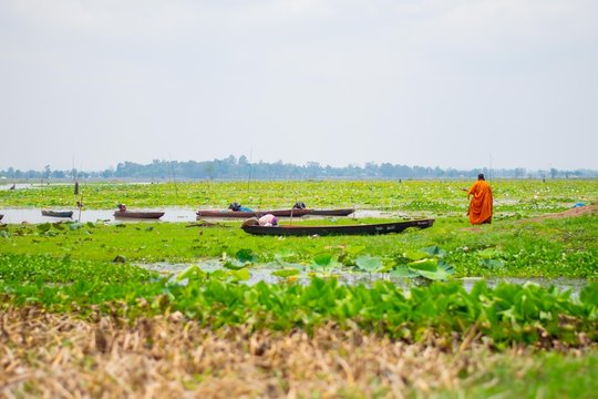 landscape view of river with fishing boat with monk in thailand