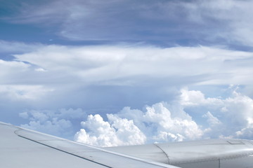 Fototapeta na wymiar plane wing and cloud floating on sky through window frame