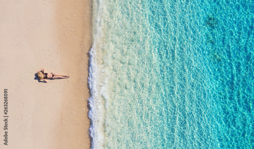 Wall mural aerial view of a girl on the beach on bali, indonesia. vacation and adventure. beach and turquoise w
