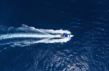 Yachts at the sea in Bali, Indonesia. Aerial view of luxury floating boat on transparent turquoise...