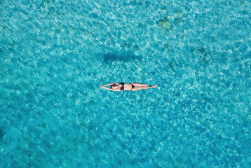 Aerial view of a girl on ocean on Bali, Indonesia. Vacation and adventure. Turquoise water. Top...