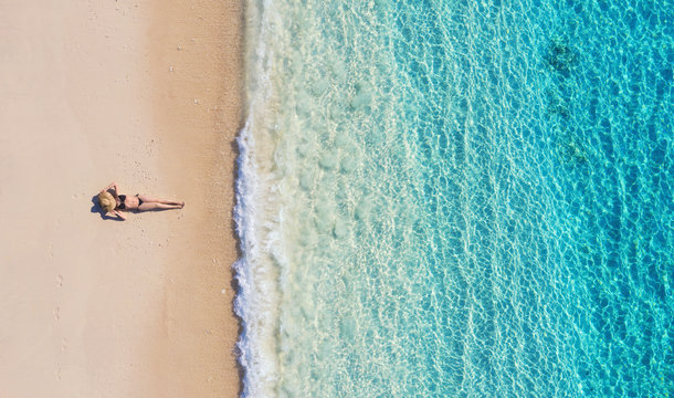 Aerial view of a girl on the beach on Bali, Indonesia. Vacation and adventure. Beach and turquoise water. Top view from drone at beach, azure sea and relax girl. Travel and relax - image