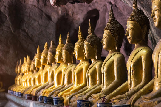 Buddha statue with light shinning through cave at Khao luang, Phetchaburi Province in Thailand.