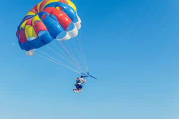 Parasailing is an extreme sport, people fly by parachute against the blue sky