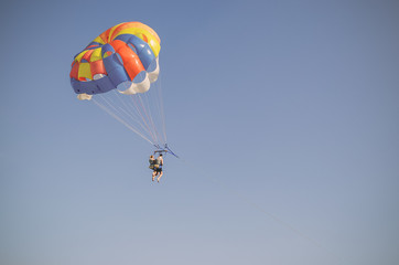 Parasailing is an extreme sport, people fly by parachute against the blue sky