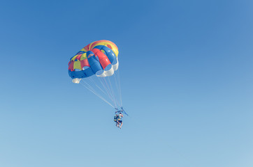 Parasailing is an extreme sport, people fly by parachute against the blue sky