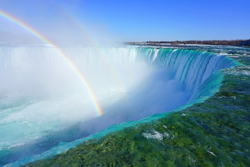 Rainbow over the Horseshoe Falls over frozen ice and snow on the Niagara River in Niagara Falls in...