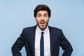 Businessman over isolated blue wall with surprise facial expression