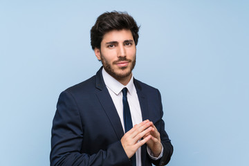 Businessman over isolated blue wall scheming something