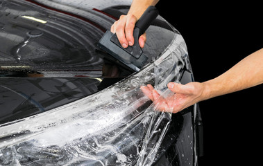 Car wrapping specialist putting vinyl foil or film on car. Protective film on the car. Applying a...