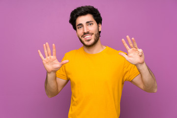 Naklejka premium Handsome over isolated purple wall counting nine with fingers