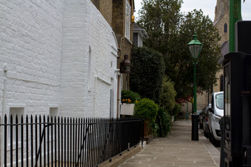 Pavement in a quiet area of London. Brick walls of houses. European style.