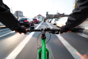 Cyclist drives on the bike path past the traffic jam - First-person view of cyclist/ motion blur