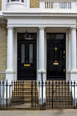 Two black Wooden Doors to residential building in London. Typical door in the English style.