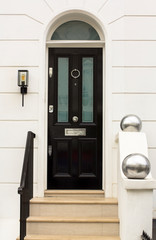 Black Wooden Entrance Door to residential building in London. Typical door in the English style.