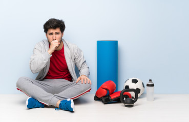 Sport man sitting on the floor is suffering with cough and feeling bad