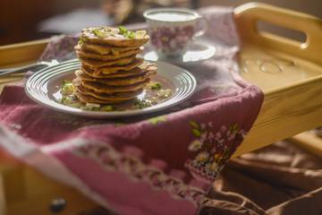 tasty breakfast in bed from eastern pancakes and Masala tea, served on the wood folding breakfast table