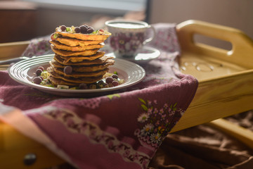 tasty breakfast in bed from eastern pancakes and Masala tea, served on the wood folding breakfast table